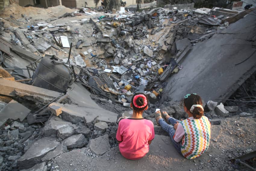Unas niñas palestinas miran los escombros de un edificio dañado en la ciudad de Gaza, el 9 de agosto de 2022. © Majdi Fathi/NurPhoto vía Getty...