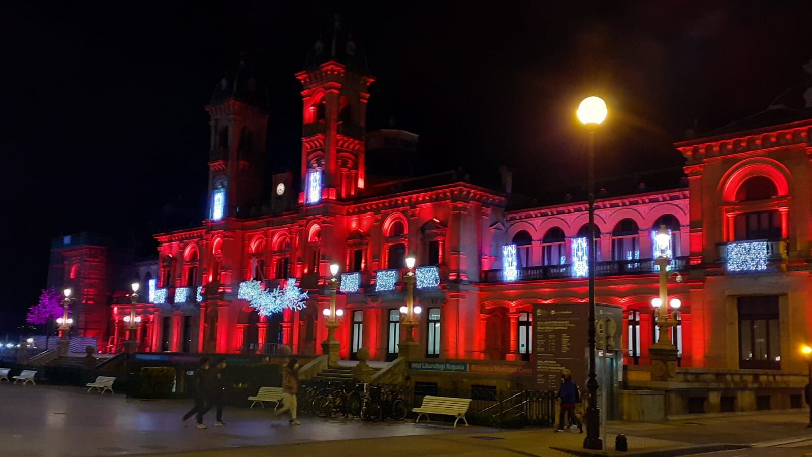 Fotografía del Ayuntamiento de Donosti por la noche, iluminado con luces rojas