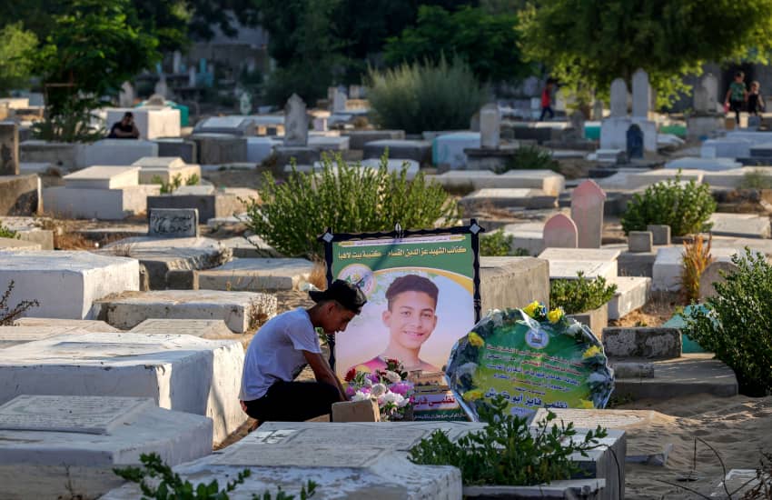 Un joven palestino sentado junto a la tumba de un amigo en el cementerio de Faluya, en Yabalia, al norte de la Franja de Gaza, el 16 de agosto de...