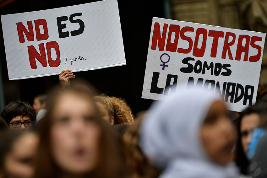 Una manifestante sostiene carteles en los que se lee ''No es No. Somos la manada'', durante una protesta contra la violencia sexual