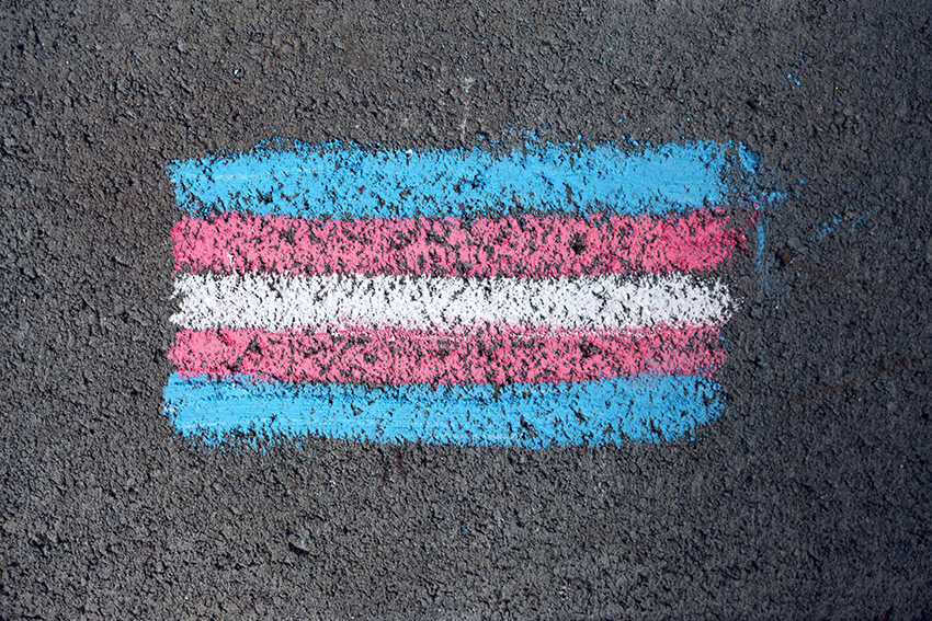 Bandera trans pintada con tiza contra la transfobia