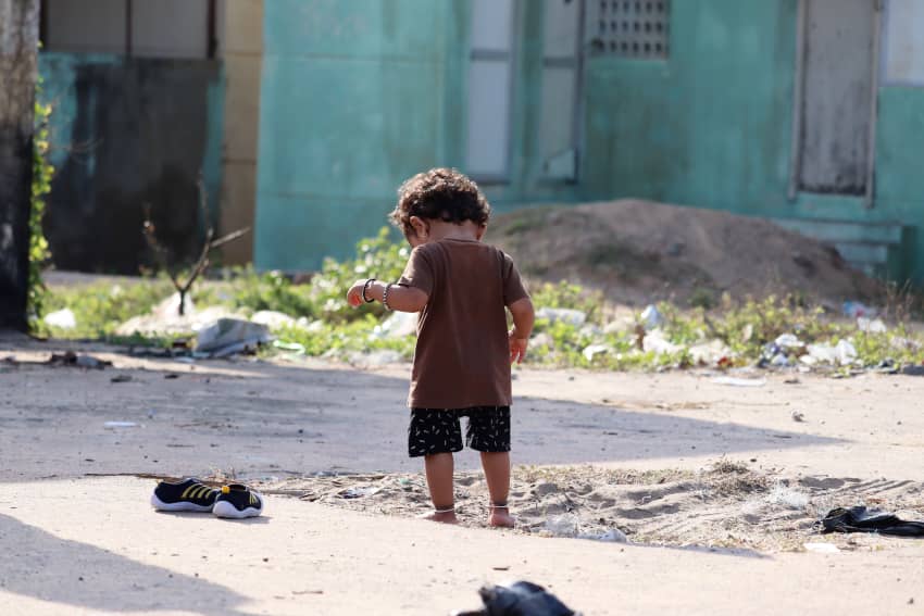 Niño pequeño descalzo en la calle, reflejo de la pobreza infantil en entornos vulnerables.