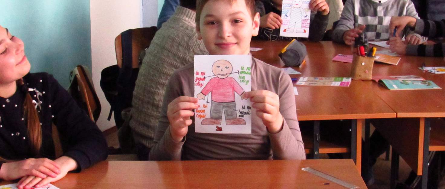 Un niño muestra un dibujo en clase